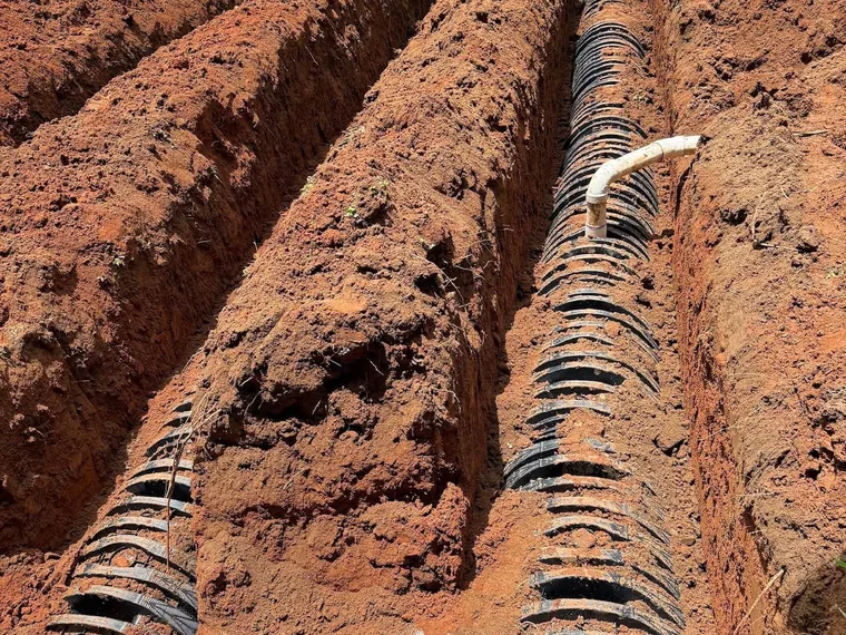 Parallel chamber drain field trench runs connected by PVC distribution lines
